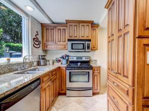 uma cozinha com armários de madeira e um forno com placa de fogão em Gordon Gem em Savannah