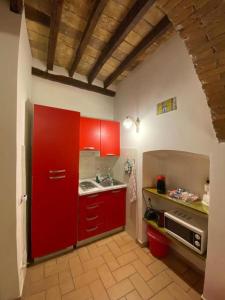 eine Küche mit roten Schränken und einem Waschbecken in der Unterkunft Casa Arco della Chiesa Nuova - Pantheon & Navona in Rom
