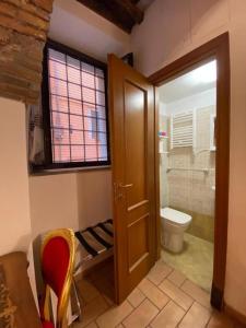 ein Bad mit einem WC, einem Fenster und einer Tür in der Unterkunft Casa Arco della Chiesa Nuova - Pantheon & Navona in Rom