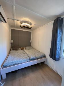 een slaapkamer met een bed in een kleine kamer bij Idyllischer Bungalow am Badesee in Reuthen
