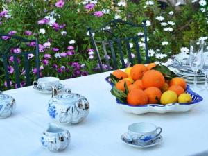 a bowl of oranges on a table with china at Benestar in El Toro