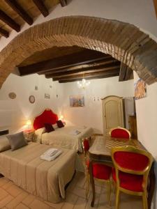 1 Schlafzimmer mit 2 Betten, einem Tisch und Stühlen in der Unterkunft Casa Arco della Chiesa Nuova - Pantheon & Navona in Rom