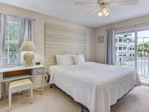 1 dormitorio con cama, escritorio y ventana en Silver Sands en Tybee Island