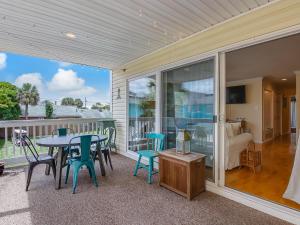 um pátio com uma mesa e cadeiras numa varanda em Silver Sands em Tybee Island