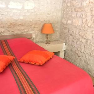 sypialnia z 2 łóżkami z czerwoną pościelą i lampką w obiekcie La Laiterie du Logis w mieście Chaniers