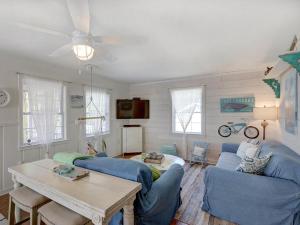 uma sala de estar com dois sofás azuis e uma mesa em Barefoot Children em Tybee Island