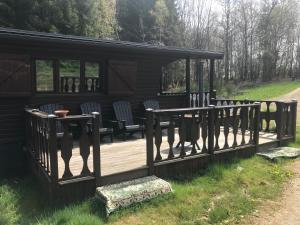 eine Holzterrasse mit Stühlen und einem Pavillon in der Unterkunft dardennen in La-Roche-en-Ardenne