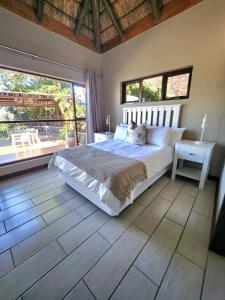 a bedroom with a large bed and a large window at ScenicViews@103 in Hartbeespoort
