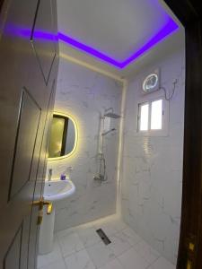 baño blanco con ducha y lavamanos en فيلا ميسرة الهدا en Al Hada