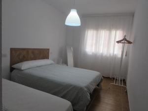 a small bedroom with two beds and a light at GARRUCHA SWEET HOME in Garrucha