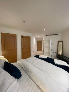 a large bedroom with two beds and a mirror at Super Modern 3-Bedroom Apartment in London