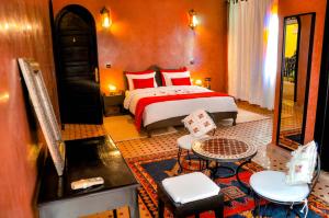 a bedroom with a bed and a table and chairs at Riad Dar Biona Maison D'hôtes & Spa in Aït Zat