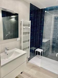 uma casa de banho com um lavatório e uma cabina de duche em vidro. em Salty Dreams Manarola em Manarola
