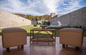 deux chaises et une table dans un patio dans l'établissement Alojamiento Turístico Pelucho Sillero, à Junín