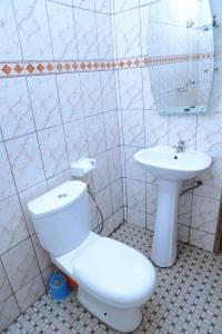 a bathroom with a toilet and a sink at Appart meuble Jouvence chez Chantal & Francis in Yaoundé +14 photos