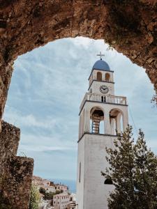 a tower with a clock on the top of it at Filoxenia Residence in Palasë