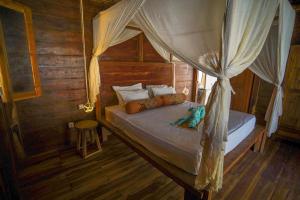 a bedroom with a bed with a canopy at Villa Motu Bingin in Uluwatu