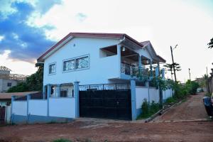 a white house with a fence in front of it at Appart meuble Jouvence chez Chantal & Francis in Yaoundé