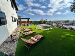 a group of chairs and a pool on a lawn at Luxurious Home - Gameroom - Cowboy Pool in San Diego