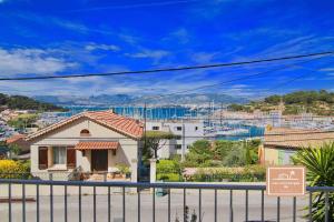 une maison avec une clôture en face d'une ville dans l'établissement villa bonheur, à Saint-Mandrier-sur-Mer