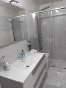 La salle de bains est pourvue d'un lavabo blanc et d'une douche. dans l'établissement Casa Vacanza da Nunzio, à Torre Annunziata