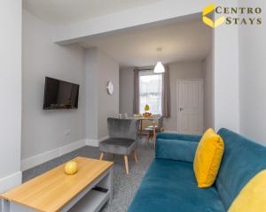 a living room with a blue couch and a table at 5-10percent Off Week Monthly Stays Families, Groups, Contractor, Relocation or Corporate Booking in Northampton