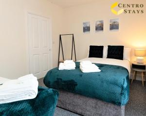 a bedroom with a bed with a blue blanket at 5-10percent Off Week Monthly Stays Families, Groups, Contractor, Relocation or Corporate Booking in Northampton