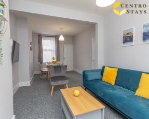 uma sala de estar com um sofá azul e uma mesa em Families Groups Contractors Relocation Free Parking & WiFi em Northampton