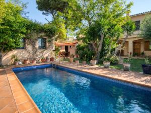 una piscina frente a una casa con árboles en Casa Villa Palafrugell 1506, en Palafrugell