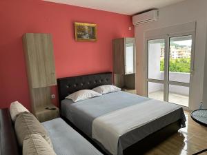 a bedroom with a bed and a red wall at Apartments Flamida in Ulcinj