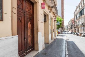 una grande porta di legno sul lato di un edificio di UrbanChicMalaga Historic Malaga Apt with Calm Private Patio a Málaga