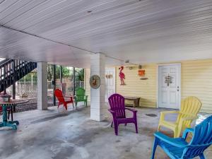 a porch with colorful chairs and a table at Tybee Tree House in Tybee Island