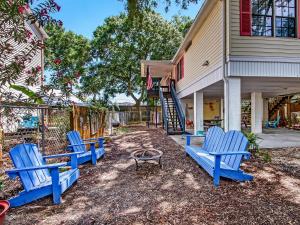 a group of blue chairs sitting outside of a house at Tybee Tree House in Tybee Island