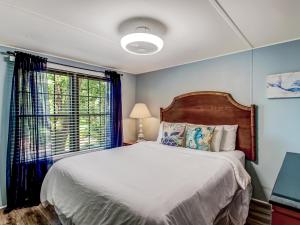 a bedroom with a large bed and a window at Tybee Tree House in Tybee Island