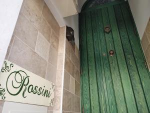a green door in a bathroom next to a wall at ROSSINI GUEST HOUSE in Martina Franca