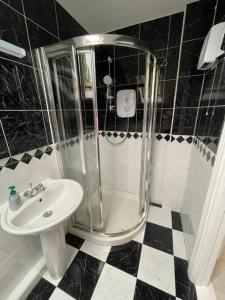 a black and white bathroom with a shower and a sink at Ballina Town Centre Duplex Apartment in Ballina