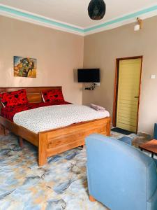 a bedroom with a bed and a blue chair at Gloton apartments in Sere Kunda