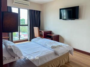 een slaapkamer met een bed, een tv en een raam bij SCSP 777 Premium 2BR2B Near Imago and KKIA in Kota Kinabalu