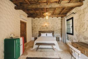 a bedroom with a bed and a green refrigerator at Suare Alaçatı in Alacati