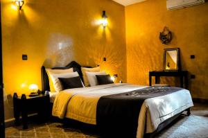 a bedroom with a large bed with yellow walls at Riad Dar Biona Maison D'hôtes & Spa in Aït Zat