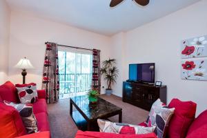 a living room with two red couches and a tv at Bahama Bay in Kissimmee