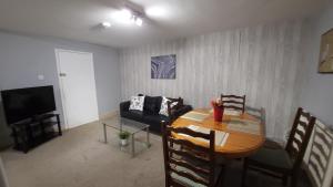 a living room with a table and a couch at Fully Furnished 3 bedroom Appartment in Bristol