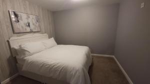 a small bedroom with a bed with white sheets at Fully Furnished 3 bedroom Appartment in Bristol
