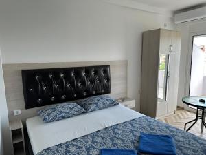1 dormitorio con 1 cama grande y cabecero negro en Apartments Flamida, en Ulcinj
