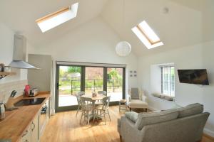 eine Küche und ein Wohnzimmer mit einem Tisch und Stühlen in der Unterkunft Scottish countryside Bothy in Arbroath