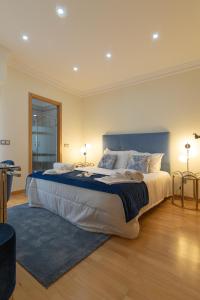 a large bedroom with a large bed with a blue headboard at Sunny, The House - AL in Faro