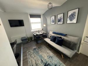 a living room with a couch and a table at Windsor Deluxe - Modern Brighton City Centre Apartment 5min from beach & station in Brighton & Hove