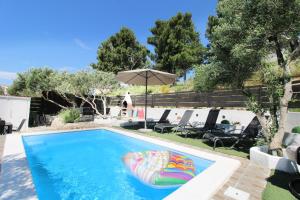 een zwembad met een opblaasbare strandbal en een parasol bij Luxury apartment Duće with private pool in Omiš