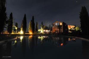 a house and a pool of water at night at Agriturismo Quarantallina in Buonconvento