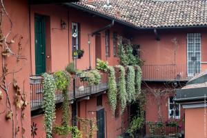 un edificio rojo con plantas a su lado en Casa Dolce Casa Alzaia Grande, en Milán